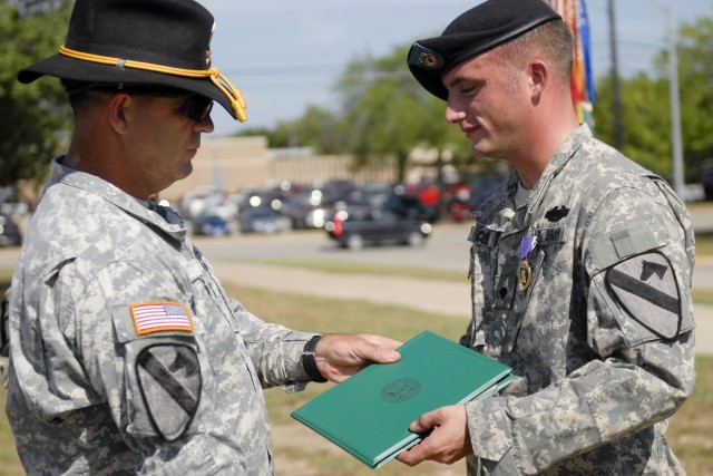 FORT HOOD, Texas-Spc. Michael Cox (right), with Headquarters and Headquarters Company, 3rd Brigade Special Troops Battalion, 3rd Brigade Combat Team, 1st Cavalry Division, receives the citation for a Purple Heart Medal from Command Sgt. Maj. James Pi...