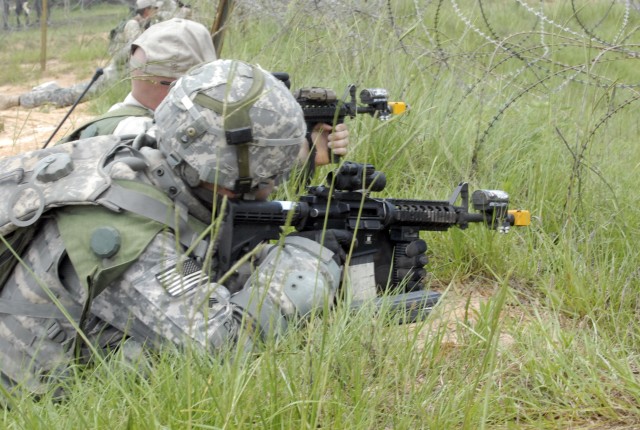 FORT POLK, La. - A role player portraying an Iraqi Army Soldier and a trooper assigned to A Battery, 5th Battalion, 82nd Field Artillery Regiment, 4th Brigade Combat Team, 1st Cavalry Division, pull security during a combat outpost training...