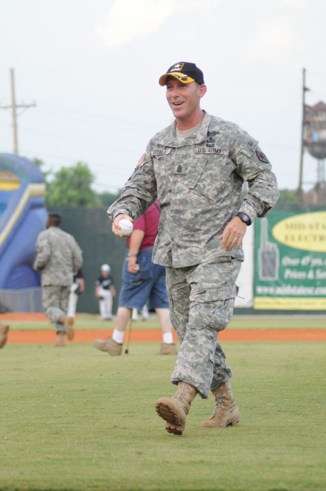 Col. Lillian Dixon, garrison commander, signs a baseball before the start of the game. In lieu of throwing a ceremonial first pitch, Fort Jackson officials tossed autographed balls