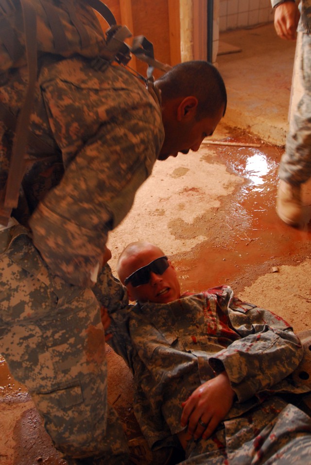 During a trauma lane training event, an Iraqi medic evaluates the simulated injuries to a 'Battle Boar' Soldier with 1st Battalion, 30th Infantry, 2nd Brigade Combat Team, 3rd Infantry Division, out of Fort Stewart, Ga., during their final test in...