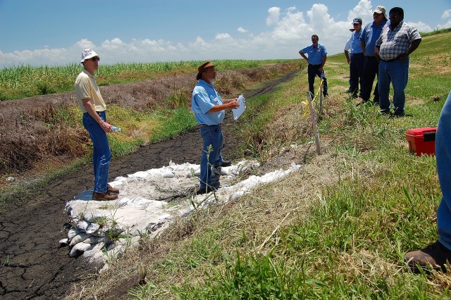 Corps employees Brent Trauger (left) and Calvin Grinslade(middle) discuss a recent small boil in the dike and its repair. 