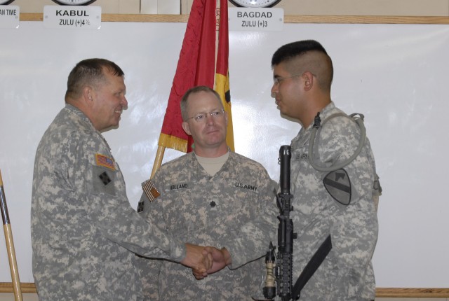 FORT POLK, La.- Gen. James Thurman (left), commander of United States Army Forces Command, gives a coin of excellence to Spc. Anthony Barrera, as his commander, Lt. Col. Joseph Holland, 2nd Battalion, 12th Cavalry Regiment, 4th Brigade Combat Team, 1...