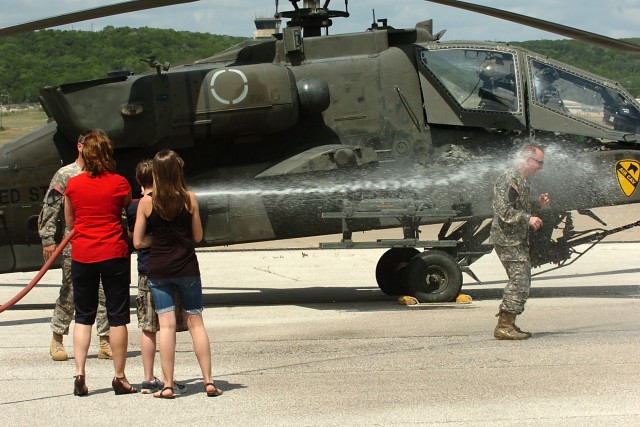FORT HOOD, Texas-Following his final flight, after 25 years in an AH-64D Apache attack helicopter, Col. Douglas Gabram, from Cleveland, Ohio, commander, 1st Air Cavalry Brigade, 1st Cavalry Division, is hosed down by his wife Lori, son Connor and...