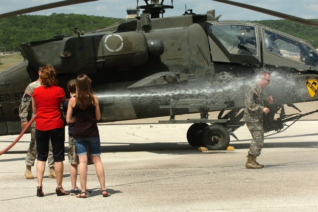 FORT HOOD, Texas-Following his final flight, after 25 years in an AH-64D Apache attack helicopter, Col. Douglas Gabram, from Cleveland, Ohio, commander, 1st Air Cavalry Brigade, 1st Cavalry Division, is hosed down by his wife Lori, son Connor and dau...