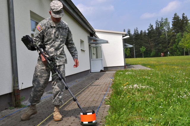 Sgt. Micah Zeidman, 57-88 Air Defense Artillery, carefully sweeps the 10.8 pound component of the Army/Navy Portable Search System (ANPSS-14), as part of a Mine Detection class, on Grafenwoehr, Germany, May 25, 2010.  The system, using a speaker...