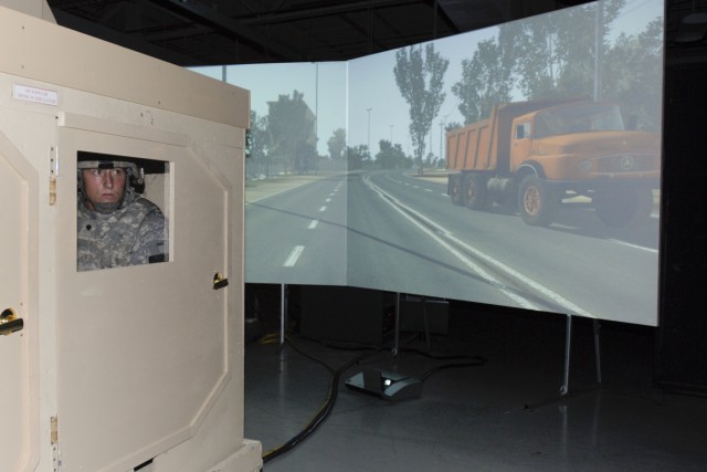 FORT HOOD, Texas-Spc. Matthew Bogar, a petroleum distribution specialist with F Forward Support Company, 215th Brigade Support Battalion, 3rd Brigade Combat Team, 1st Cavalry Division surveys the area outside his window while an on-screen dump truck ...