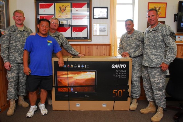 FORT HOOD, Texas- Col. John Peeler (far right), commander, 2nd Brigade Combat Team, 1st Cavalry Division, and Command Sgt. Maj. Emmett Maunakea (second right), received a 50-inch television on behalf of "Black Jack" Soldiers from the Fort Hood...