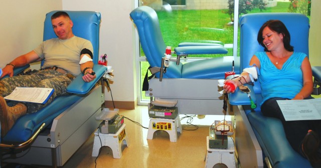 FORT HOOD, Texas- Lt. Col. Matthew Ruedi (left), commander of the 15th Brigade Support Battalion, 2nd Brigade Combat Team, 1st Cavalry Division, and wife Cindy share a cubicle as they donate blood during the battalion's blood drive at the...