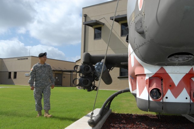 FORT HOOD, Texas - Spc. Cecil Wong, from Dallas, a paralegal specialist for 1st Air Cavalry Brigade, 1st Cavalry Division, looks at a Cobra helicopter as he takes in his new surroundings at the 1st ACB headquarters building, here, July 15. Wong...