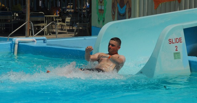 FORT HOOD, Texas-Pfc. Matthew Ella, a Livermore, Calif. native and a signal specialist with 3rd Battalion, 82nd Field Artillery Regiment, 2nd Brigade Combat Team, 1st Cavalry Division, shoots out the end of a waterslide during a Better...