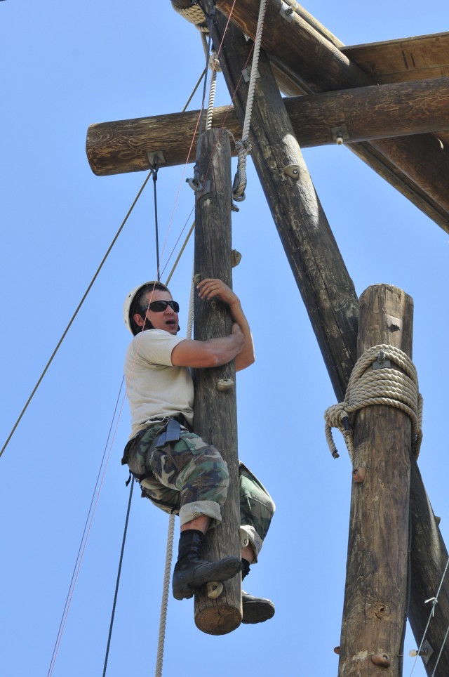 Capt. George Lambos, commander of Headquarters and Headquarters Battery for the 100th Missile Defense Brigade (Ground-Based Midcourse Defense), climbs to the top of Alpine Tower using one of the swinging poles.  The tower climb was a part of a teambu...