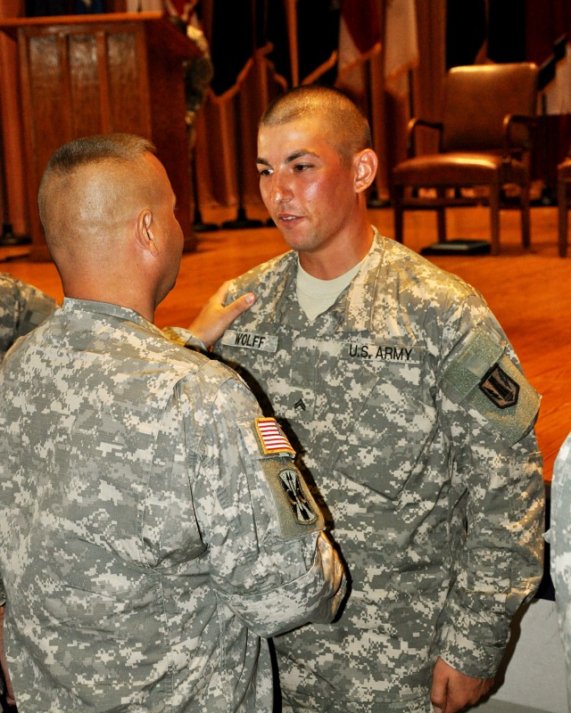 FORT HOOD, Texas-Cpl. Jeremy Wolff (right), a multiple launch rocket system crew member from Littleton, Colo., with A Battery, 1st Battalion, 21st Field Artillery Regiment, 41st Fires Brigade, receives a handshake and congratulations from Lt. Col. Ja...