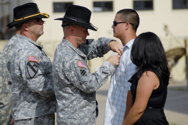 FORT HOOD, Texas - Col. Douglas Crissman, the commander of 3rd Brigade Combat Team, 1st Cavalry Division, pins a Purple Heart Medal on former Sgt. Juan Castro, here, July 26.  Castro sustained injuries as part of a combat logistical convoy in Diyala ...