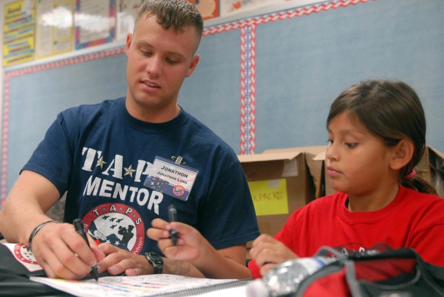 FORT HOOD, Texas - Houston native, Spc. Jonathon Long, an infantry soldier assigned to 2nd Battalion, 5th Cavalry Regiment, 1st Brigade Combat Team, 1st Cavalry Division, colors with a young girl during the Good Grief Camp on Fort Hood, July 23....