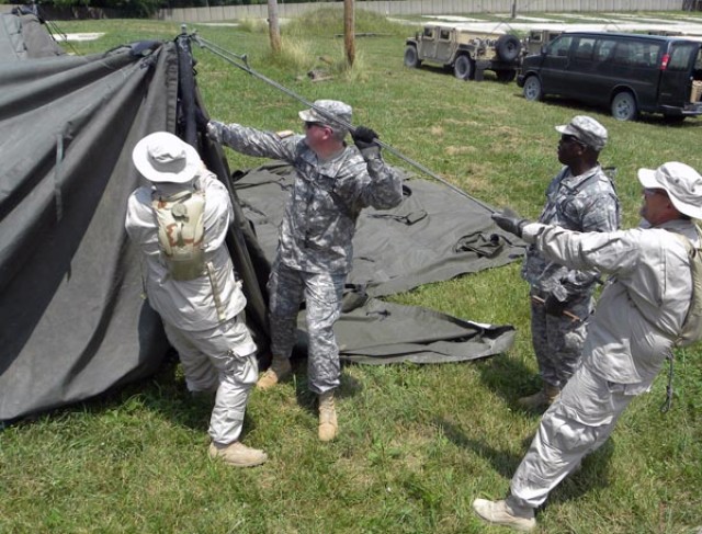 Lt. Col. Douglas Hoenig, executive officer and Master Sgt. Regenal McGriff, operations sergeant, 533rd Engineer Detachment, Forward Engineer Support Team - Main assist Corps team members in setting up a tent to serve as a tactical operations center d...