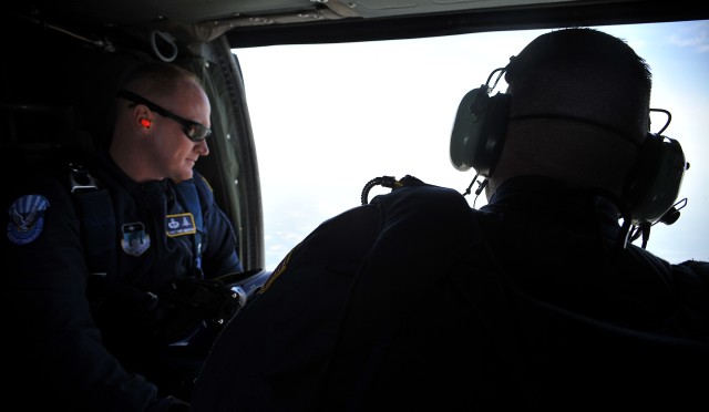 Air Force Tech. Sgts. Tony Anderson and Kenny Kendrick, members of the U.S. Air Force Academy Wings of Blue Jump Team, look down at set-up procedures while on a U.S. Army UH-60 Black Hawk helicopter July 25. The team will perform at the Boy Scouts of...