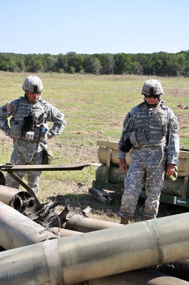 FORT HOOD, Texas-Staff Sgt. Randell Evans (left), from Abilene, Texas, the battalion master gunner for 2nd Battalion, 20th Field Artillery Regiment, and Lt. Col. Brian Hammer, the battalion's commander, inspects the damage of the destroyed missile...
