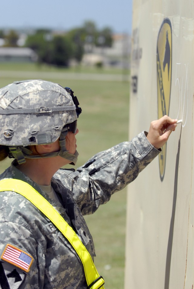 FORT HOOD, Texas- Spc. Vanessa Cross, a native of Pittsfield, Maine, assigned to the 27th Brigade Support Battalion, 4th Brigade Combat Team, 1st Cavalry Division, marks a shipping container prior to a safety inspection conducted by civilians from...