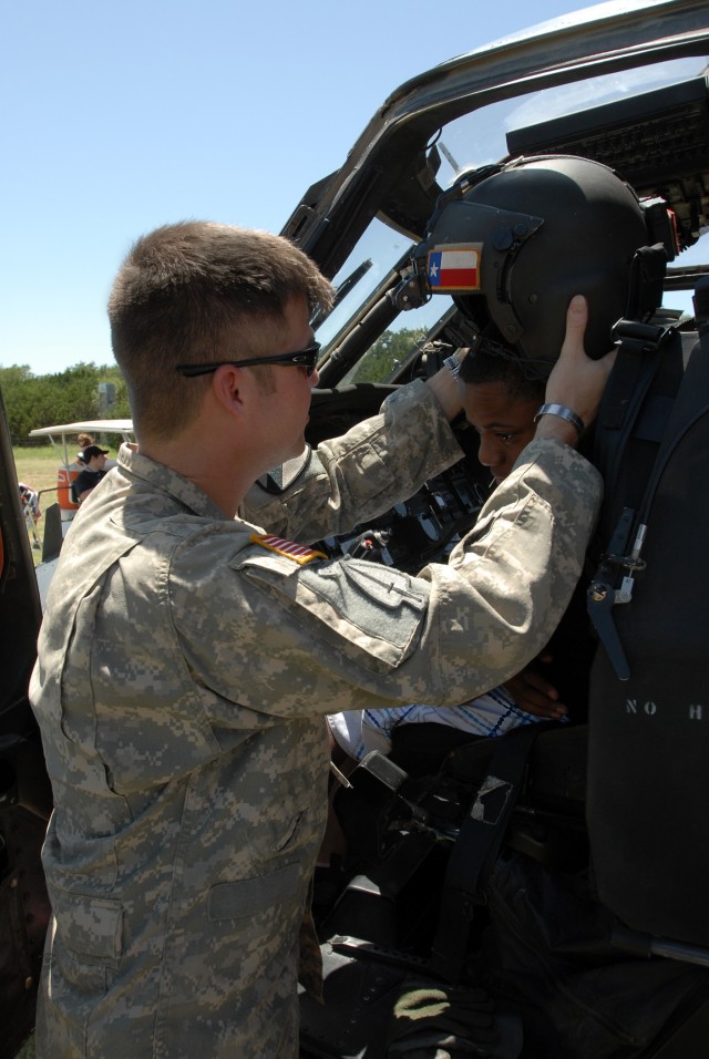KILLEEN, Texas - Chief Warrant Officer 2 Joshua Aronack (left), from Houston, a Black Hawk pilot with Company C, 3rd Assault Helicopter Battalion, 227th Aviation Regiment, 1st Air Cavalry Brigade, 1st Cavalry Division, helps place a helmet on...