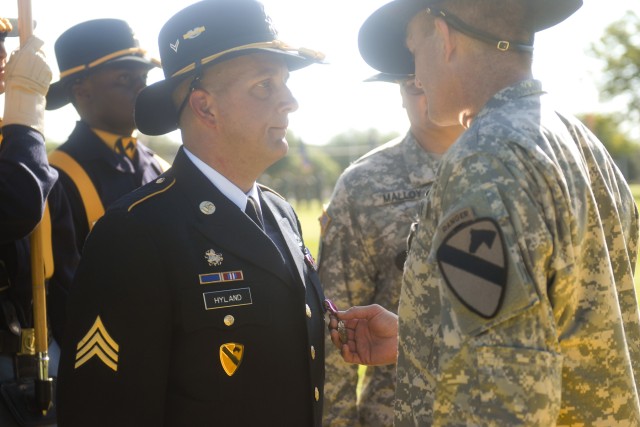 FORT HOOD, Texas - Sgt. John Hyland (left), a former 6th Squadron, 9th Cavalry Regiment, 3rd Brigade Combat Team, 1st Cavalry Division Soldier, who was injured in Iraq by a roadside bomb, receives the Meritorious Service Medal from Maj. Gen. Daniel A...