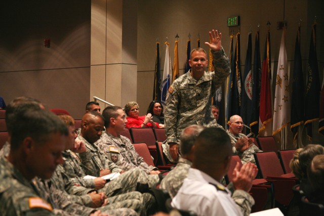 Lt. Col. Karl Kraus, U.S. Army Space and Missile Defense Command/Army Forces Strategic Command deputy chief of staff, G8, waves hello to the command’s employees who attended the town hall Aug. 9 at the Bob Jones auditorium after being introduced...