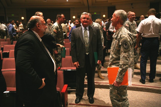 Lt. Gen. Kevin T. Campbell, U.S. Army Space and Missile Defense Command/Army Forces Strategic Command commanding general, congratulates John Fairlamb, center, the command’s military adviser, and John Cummings, public affairs specialist for the...