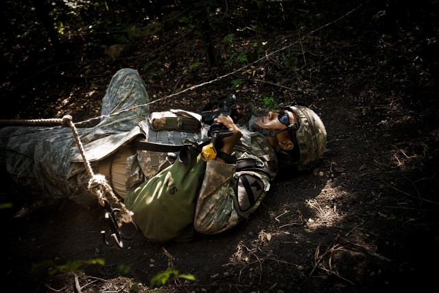 FORT HOOD, Texas-Spc. Jeffrey Santos, from Killeen, Texas, a medical supply Soldier with 1st Brigade Combat Team, 1st Cavalry Division, negotiates his way through a barbed wire obstacle on the warrior skills lane during the 1st Cav. Div. Expert Field...