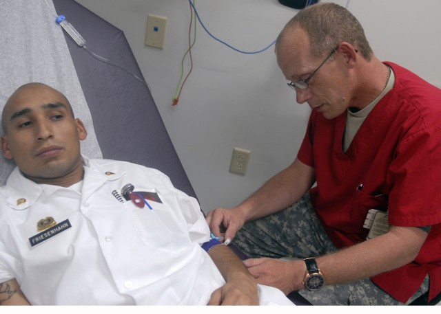 FORT HOOD, Texas - Spc. James Pearce, from Lebanon, Mo., a medic with 6th Squadron, 9th Cavalry Regiment, 3rd Brigade Combat Team, 1st Cavalry Division, starts an intravenous drip on Spc. Jimmy Friesenhahn during medical proficiency training at Fort ...