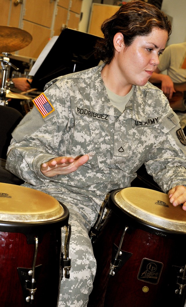 FORT HOOD, Texas-Pfc. Amarilys Rodriguez, from Puerto Rico, an orderly room clerk for the 67th Forward Support Company, 1st Battalion, 21st Field Artillery Regiment, plays the congas during practice with the Los Cavalleros at the 1st Cavalry...