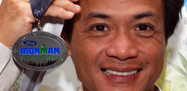 Displaying his iron &lt;alt tag&gt; image - Peck Ha displays his Ironman medal &lt;/alt tag&gt;