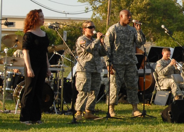 FORT HOOD, Texas - April Hayes (left) from Westerville, Ohio, a guest singer from Vive Les Arts Theatre, sings the song "Wicked," written by Stephen Schwartz, along with Spc. Breanna Lemons (center) from Conroe, Texas, a clarinet player for the 1st C...