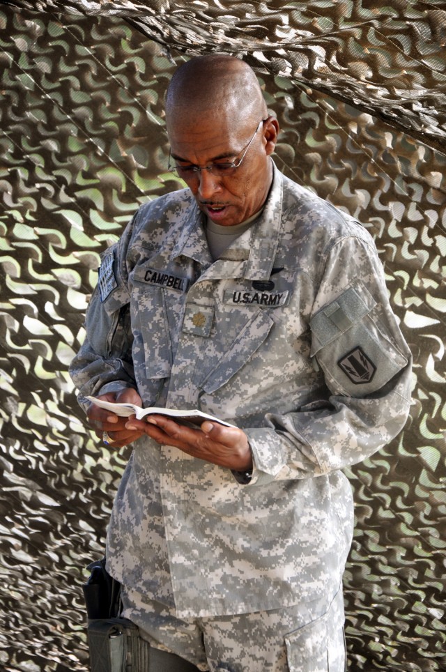 FORT HOOD, Texas-Maj. Anthony Campbell, a Lockhart, Texas native, reads a prayer to other Soldiers of the 41st Fires Bde. attending a field Mass, Sept. 24. Campbell was once a Eucharistic minister- someone who assists the priest during Communion...