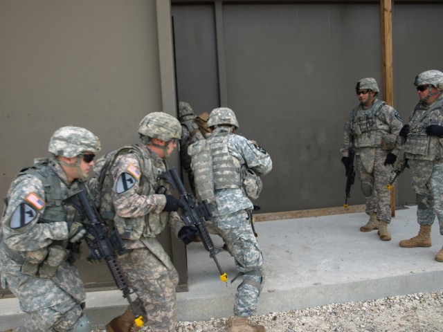 Fort Hood, Texas - Soldiers from Company A, 2nd Battalion, 8th Cavalry regiment, 1st Brigade Combat Team, 1st Cavalry Division, rush in to clear a "shoot house" as part of Urban Warfare Sept. 21. This training is conducted with live rounds on targets...