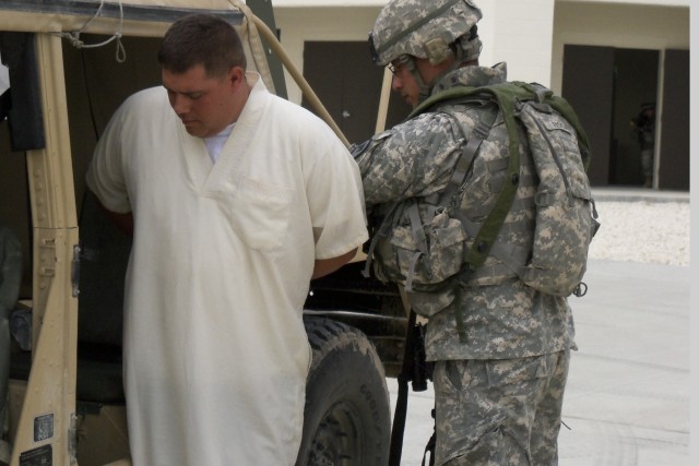 FORT HOOD, Texas - Troopers from 6th Squadron 9th Cavalry Regiment, 3rd Brigade Combat Team, 1st Cavalry Division, escort a detained person while conducting a cordon and search at the Boaz Combined Arms Combat Training Facility as part of a...