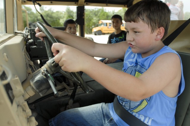 Jakeb Dickerson, from Belton, pretends to drive a high mobility, multi-wheeled vehicle Sept. 24 as part of a field day hosted by 3rd Battalion, 8th Cavalry Regiment, 3rd Brigade Combat Team, 1st Cavalry Division. The battalion invited the two...