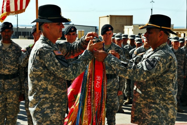 FORT HOOD, Texas-Lt. Col. Nathan Cook (left), commander, 3rd Battalion, 82nd Field Artillery Regiment, 2nd Brigade Combat Team, 1st Cavalry Division, and Command Sgt. Maj. Carlos Soto Bonilla attach a Meritorious Unit Commendation streamer to the top...