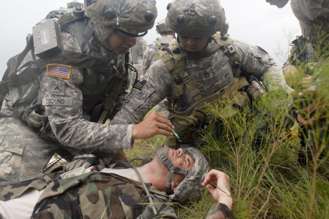 FORT HOOD, Texas-Sgt. 1st Class Shane Hanover (right), a platoon sergeant with 3rd Brigade Combat Team, 1st Cavalry Division, helps his Soldier apply a tourniquet to a simulated casualty as part of a combat casualty care lane. The exercise was part o...