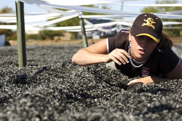FORT HOOD, Texas- Katrina Moon, the spouse of a Soldier with Headquarters and Headquarters Company, 215th Brigade Support Battalion, 3rd Brigade Combat Team, 1st Cavalry Division, low crawls through part of an obstacle course during the brigade's Spo...