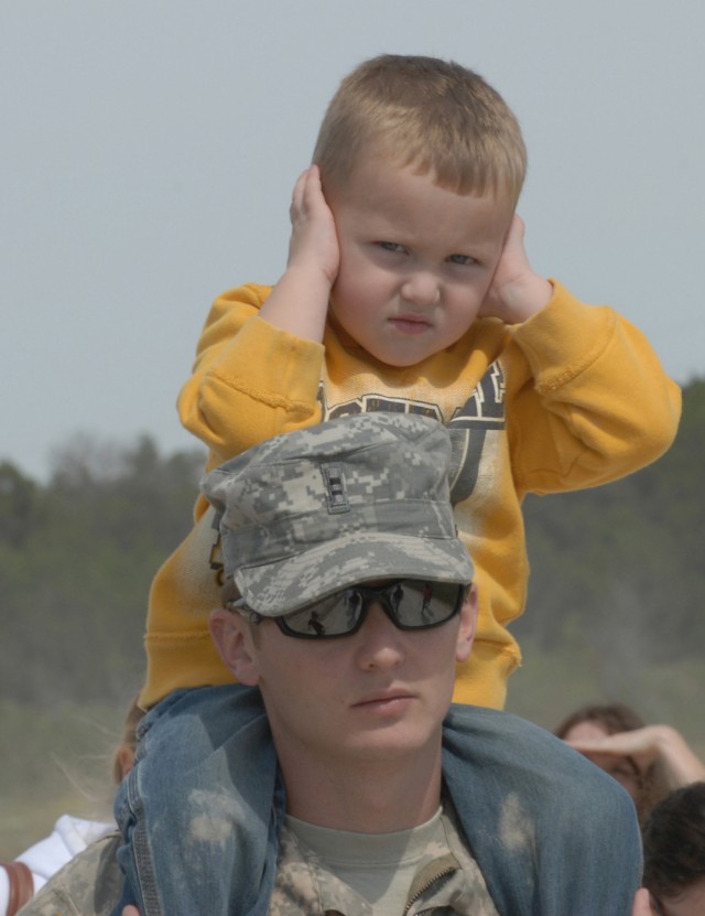 FORT HOOD, Texas-CW2 Jack Hughes, a pilot with A Company, 1st Attack Reconnaissance Battalion, 227th Aviation Regiment, 1st Air Cavalry Brigade, 1st Cavalry Division, holds his son on his shoulders as his son reacts to the loud noise provided by...