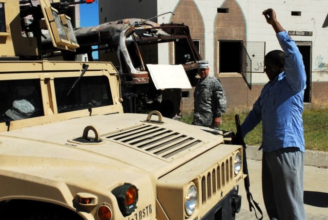 Pfc. Marcus Green, a Baltimore native playing an opposition force for 15th Brigade Support Battalion, 2nd Brigade Combat Team, 1st Cavalry Division, stops a vehicle full of Soldiers participating in convoy operations training on Fort Hood, Texas,...