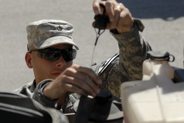 FORT HOOD, Texas- Pfc. Jason Earley, with 3rd Brigade Combat Team, 1st Cavalry Division, checks the oil of a mine resistant ambush protected  vehicle during an operator's course on Fort Hood. The brigade conducted the course to keep its Soldiers...