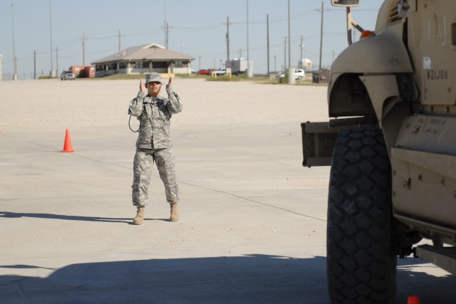 FORT HOOD, Texas- Pfc. Jenny Cueva, with 3rd Brigade Combat Team, 1st Cavalry Division, ground guides a mine resistant ambush protected vehicle 5 as part of an operator's course to keep the brigade up-to-date on equipment used in combat today. The ve...