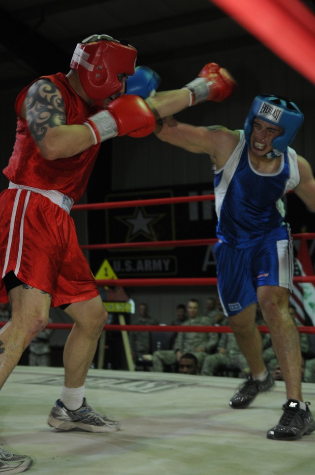 Spc. Henry Ruiz (right), punches his opponent, Staff Sgt. Chris Kennebeck, Oct. 9 during their bout in the Boxing Smoker 2, an event hosted by Division Special Troops Battalion, 1st Armored Division, United States Division - Center, at Camp Liberty, ...