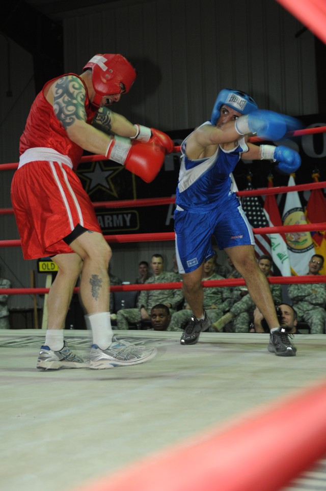 Spc. Henry Ruiz (right), punches his opponent, Staff Sgt. Chris Kennebeck, Oct. 9 during their bout in the Boxing Smoker 2, an event hosted by Division Special Troops Battalion, 1st Armored Division, United States Division - Center, at Camp Liberty, ...