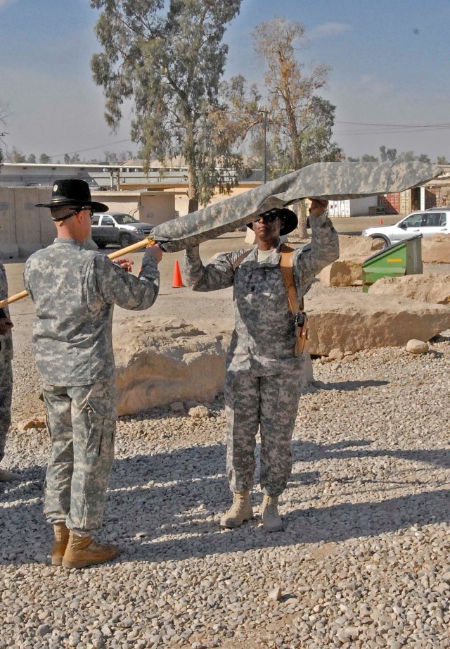 CONTINGENCY OPERATING SITE MAREZ, Iraq -Lt. Col. Eric Land (left), commander of the 4th Brigade Special Troops Battalion, 4th Advise and Assist Brigade, 1st Cavalry Division, and Command Sgt. Maj. Cassandra Redd uncase the battalion colors during...