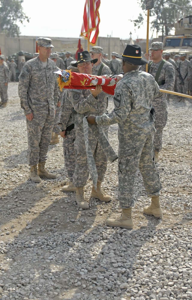 CONTINGENCY OPERATING SITE MAREZ, Iraq - Lt. Col. Robert Magee (center), commander of the 5th Battalion, 82nd Field Artillery Regiment, 4th Advise and Assist Brigade, 1st Cavalry Division, and Command Sgt. Maj. Calvin Coler, uncase the battalion's...