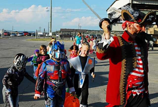 FORT HOOD, Texas- 1st Sgt. Theodore Durand, Headquarters and Headquarters Battery, 3rd Battalion, 82nd Field Artillery Regiment, 2nd Brigade Combat Team, 1st Cavalry Division, leads a group of costumed children on a Halloween-themed parade through th...