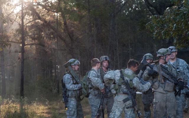 Soldiers huddle up during a "tactical freeze" portion of the Full Spectrum Operation exercise in Ft. Polk, LA, Saturday, Oct. 23, 2010.  The Full Spectrum exercise focuses on facing and defeating a hybrid threat representing both an insurgent force a...