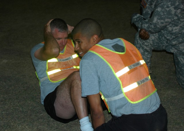 FORT HOOD, Texas-Lt. Col. Brian Hammer (left), battalion commander of the 2nd Battalion, 20th Field Artillery Regiment, 41st Fires Brigade, focuses on proper form while doing sit ups during the brigades' officer APFT Challenge, Oct. 19.  Hammer's bat...