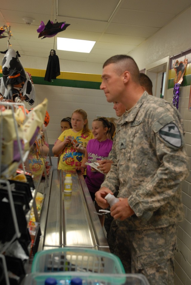 BELTON, Texas- Kalamazoo, Mich. native, Sgt. Jeremy Pelletier, a forward observer with 2nd Battalion, 5th Cavalry Regiment, 1st Brigade Combat Team, 1st Cavalry Division, waits in the lunch line with the students from Leon Heights Elementary...